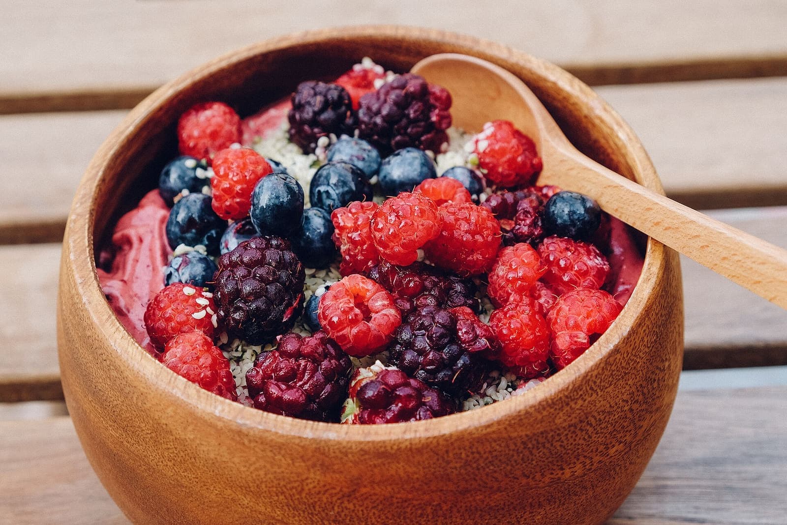 Tigela de madeira com frutas vermelhas e açaí